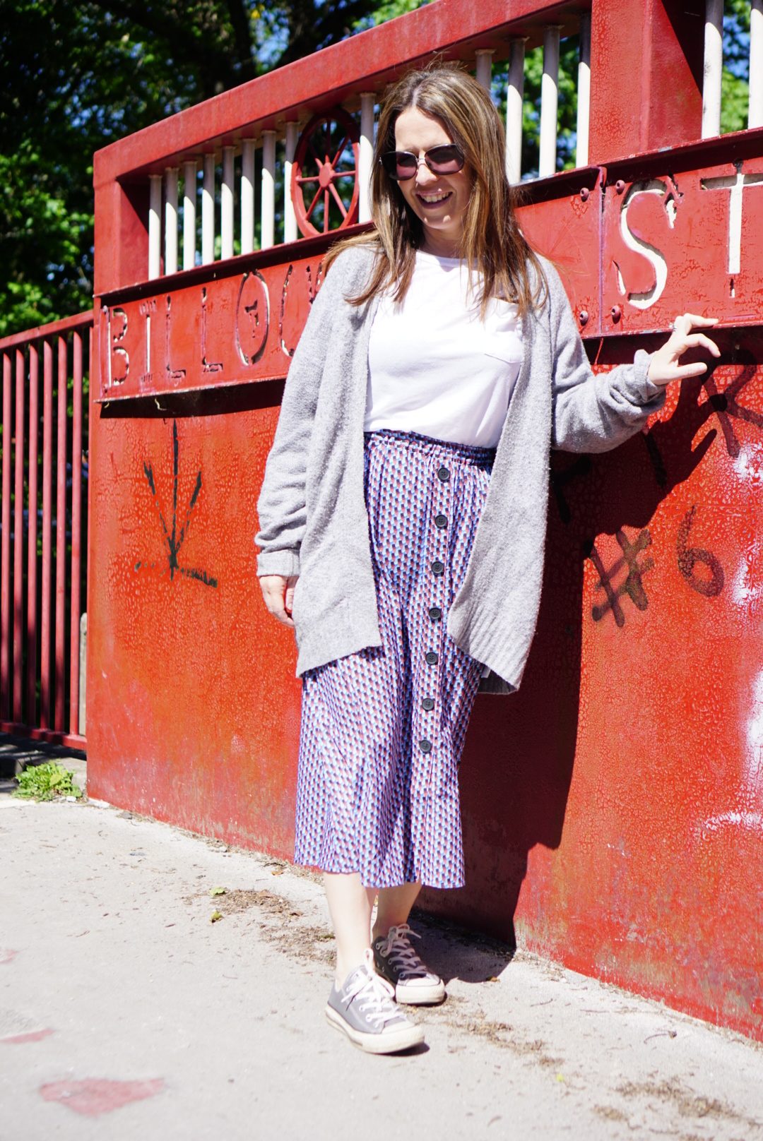 A women leaning against a red wall