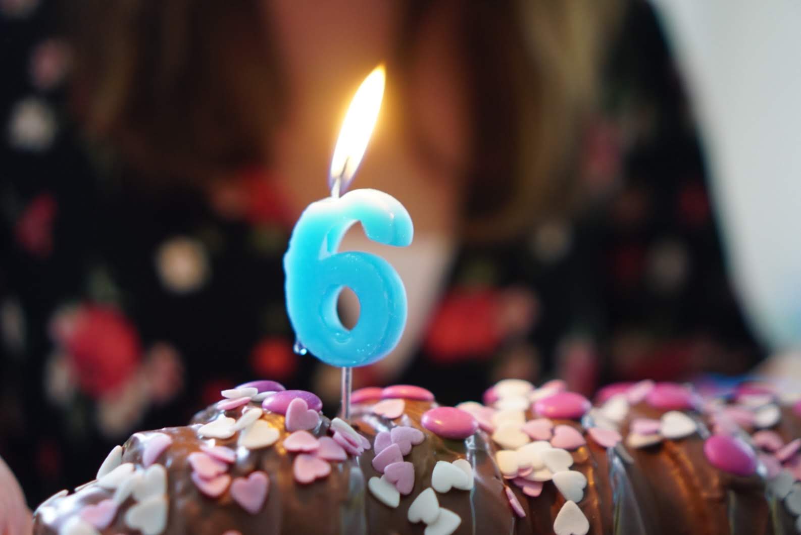 a number six candle on a chocolate cake